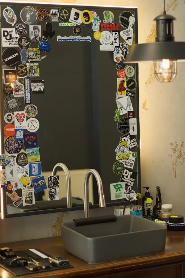 Stanowisko barberskie z lustrem oklejonym naklejkami w Piglobarbershop w Koninie